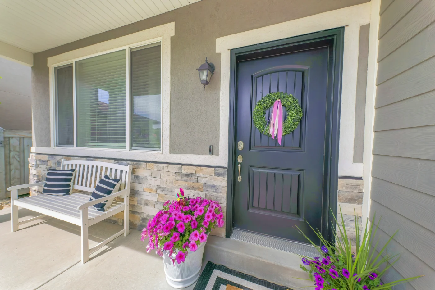 Blue door with decorative wreath and simple front porch