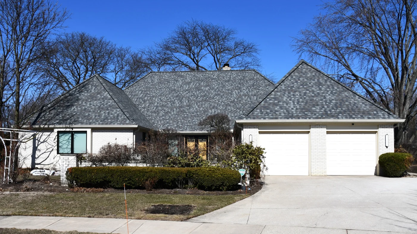Home with white siding and two garage doors with beautiful CertainTeed asphalt shingle roofing