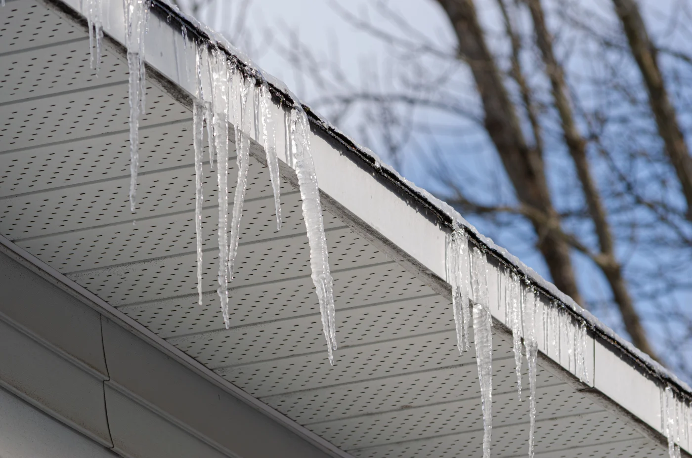 Apex Exteriors New Home Soffit Services In The Chicagoland Area There are icicles forming, hanging down from a roof, and below it is perfectly-installed white soffit.