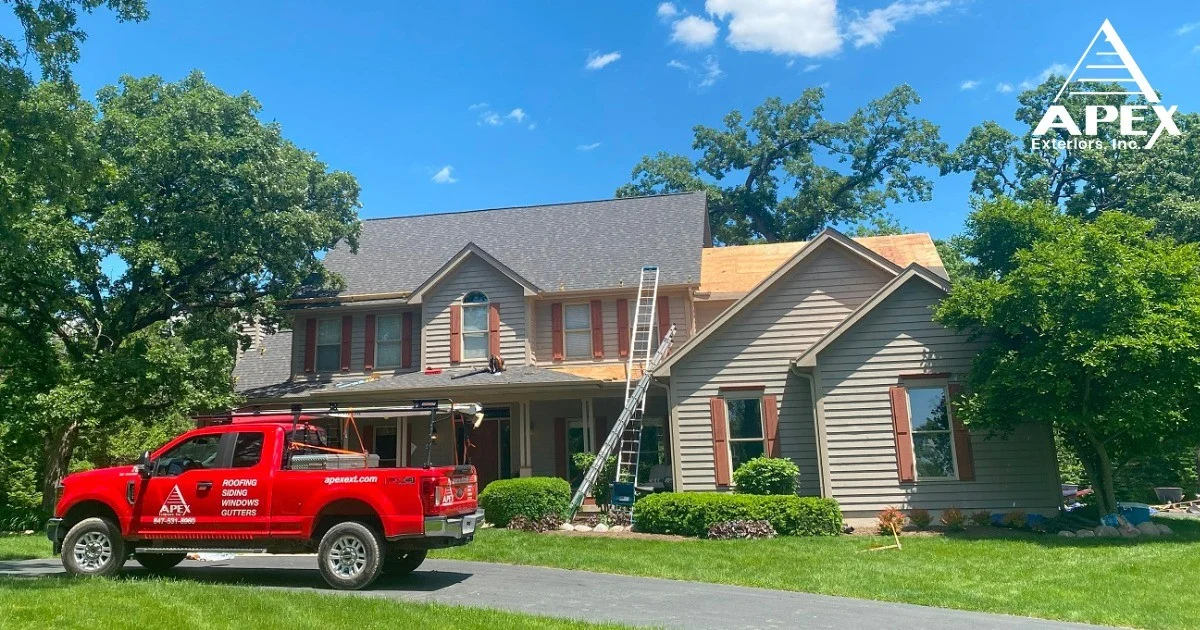Chicagoland – Where Apex Exteriors Residential Roof Repair Teams Get To Work! A red Apex Exteriors truck outside a home getting new siding and roofing installed.