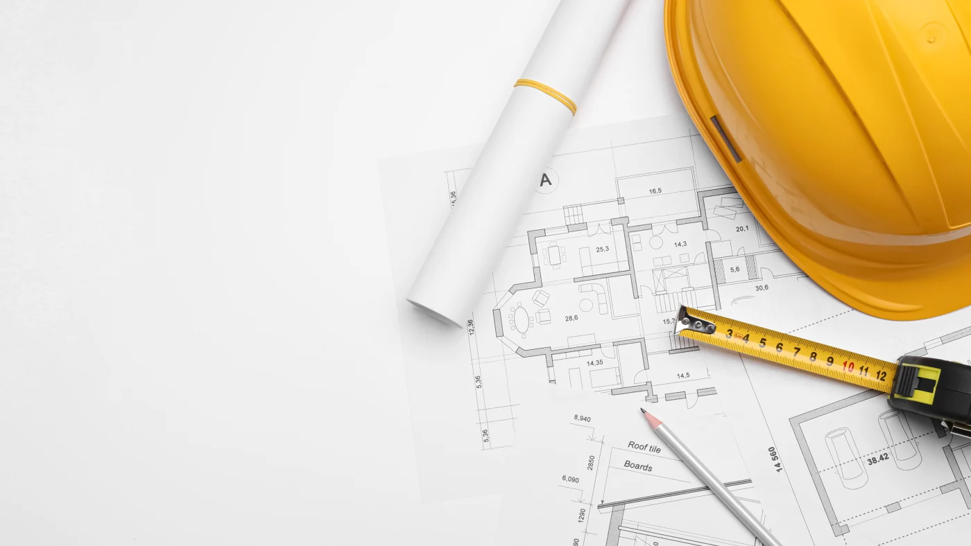 Apex Exteriors Chicagoland Exterior Projects Process Step 3 Proposal Development Architectural blueprints and planning tools are laid out beside a yellow hard hat and measuring tape. This setup conveys the precision and planning behind every Apex Exteriors project proposal across Chicagoland.