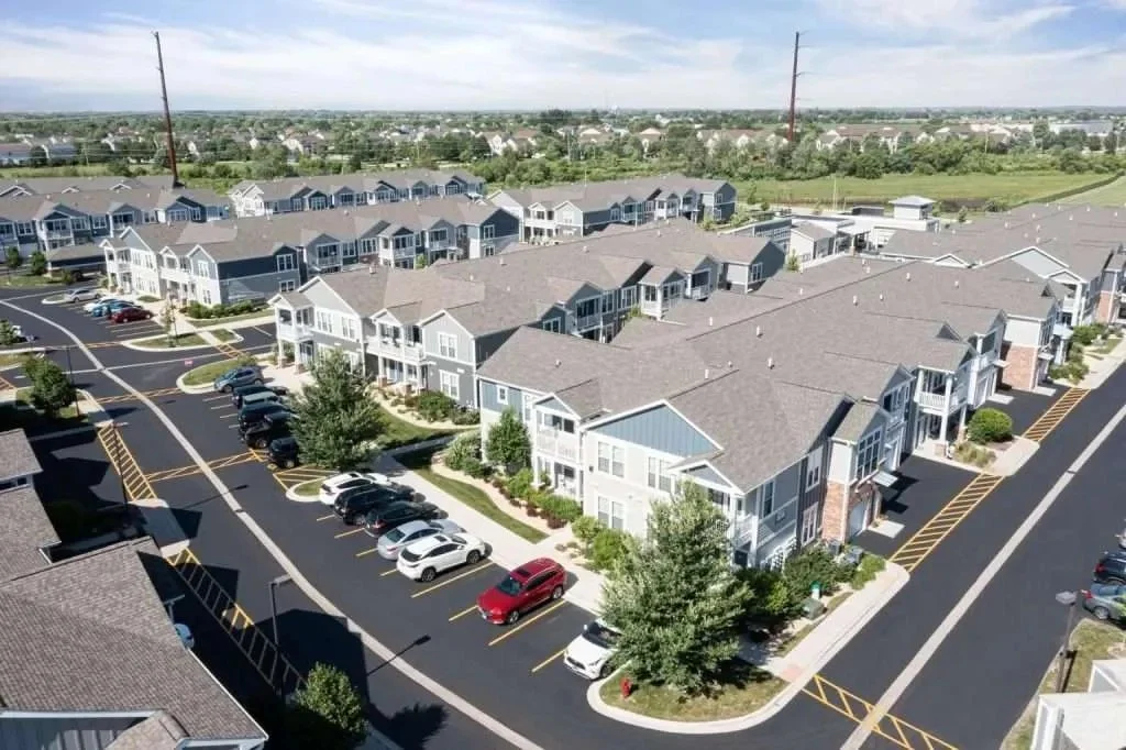 A large multi-family housing complex with clean rooflines and uniform gutters, reflecting Apex Exteriors’ high-caliber workmanship and attention to detail on complex Chicagoland installations.