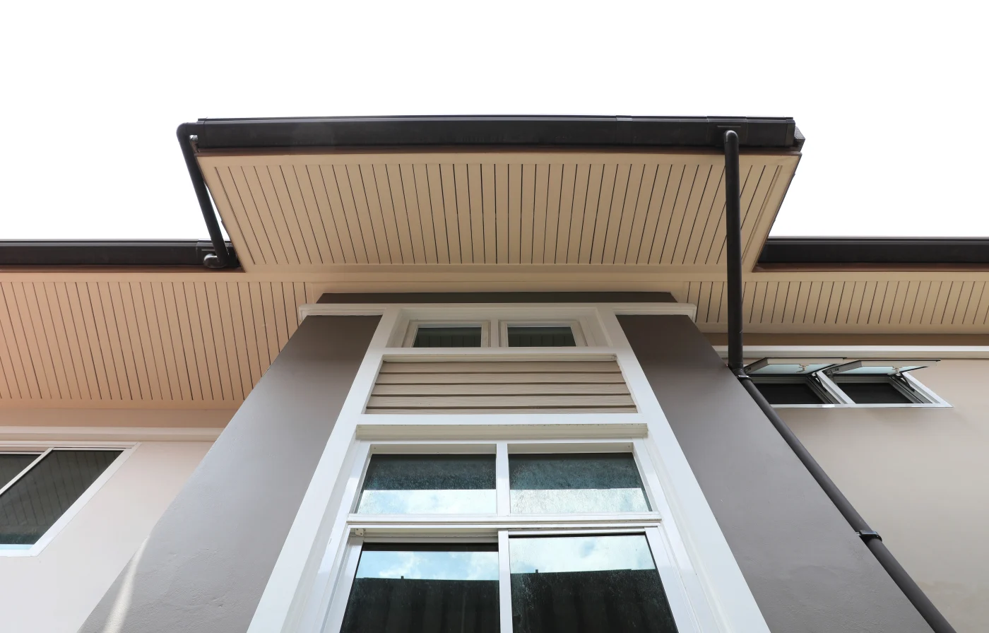 An upward view of a multi-family building’s eaves, emphasizing a clean and uniform soffit installation. The vented panels run horizontally beneath the overhang, supporting proper attic ventilation while delivering a crisp, finished look. This image highlights expert soffit work on large-scale residential structures.