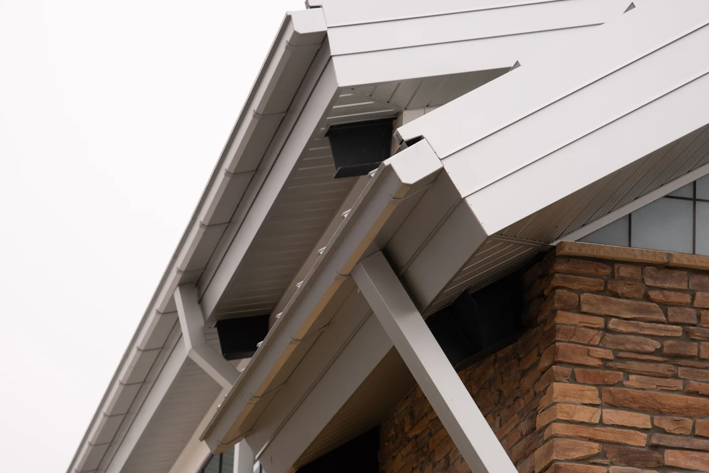 This image features a charming brick house with a newer-looking white gutter system.