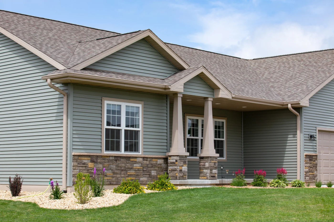Gray house with a porch and a shingle roof