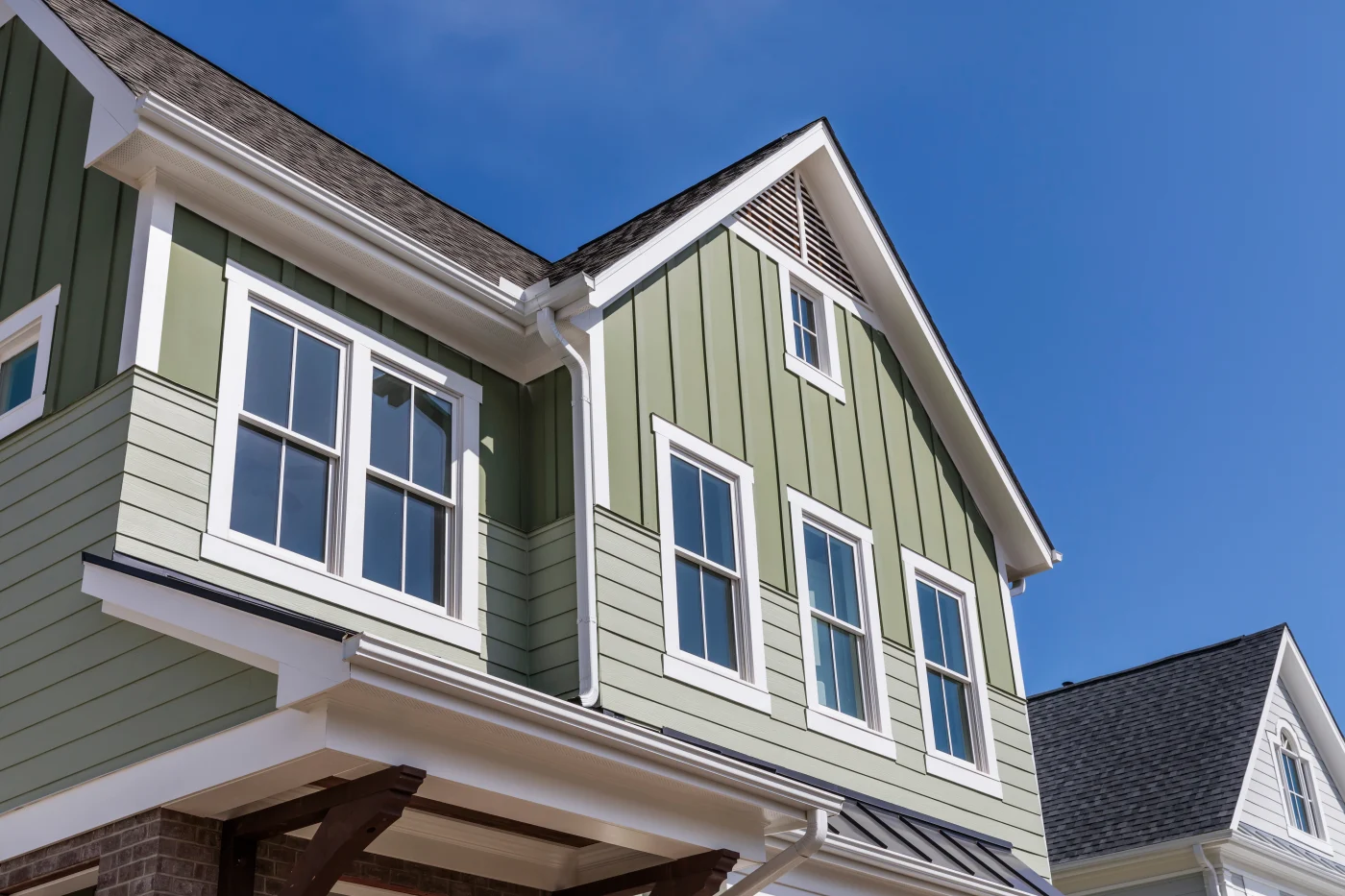 New house with green vertical siding and new windows