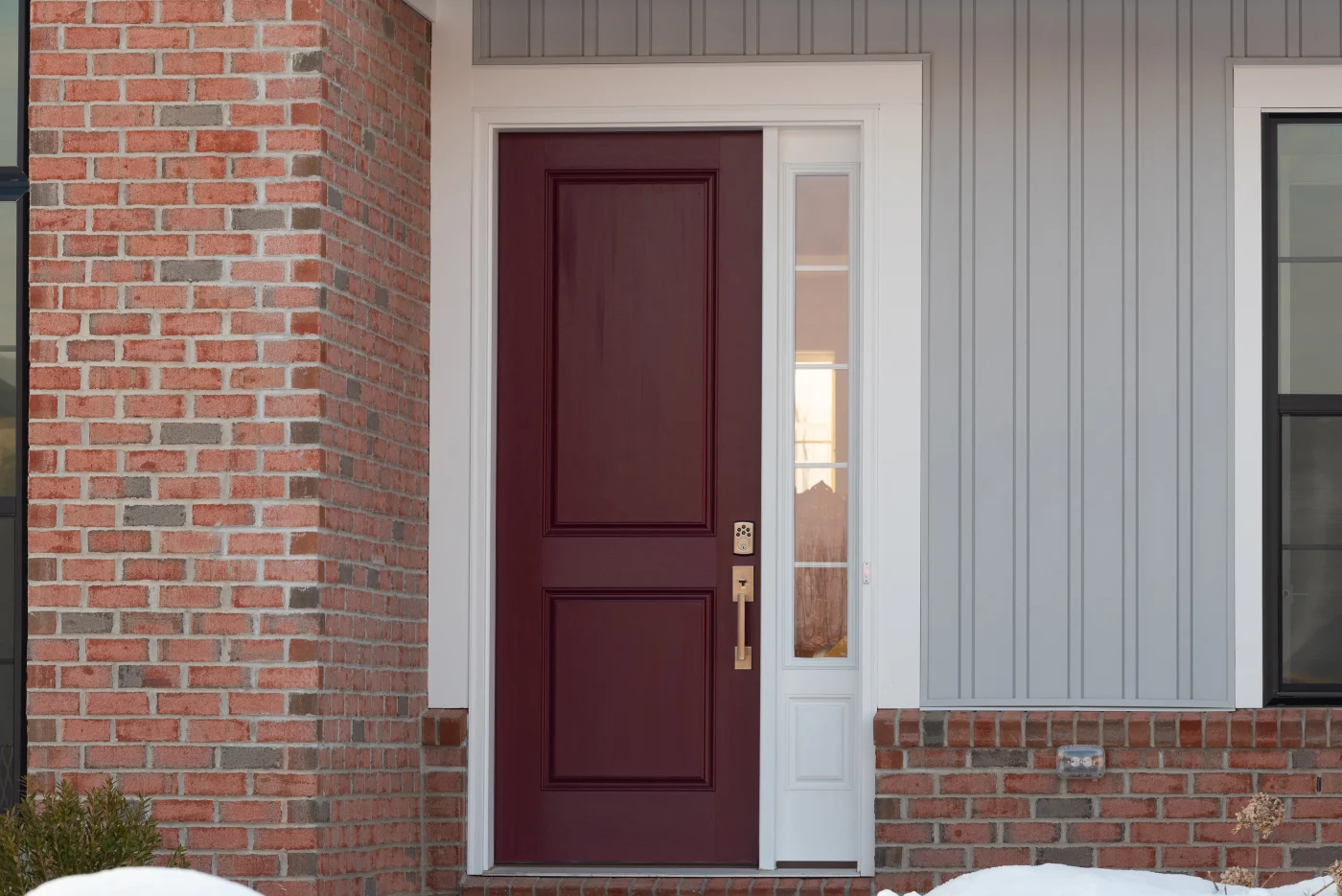 Front of the home with a burgundy colored entry door