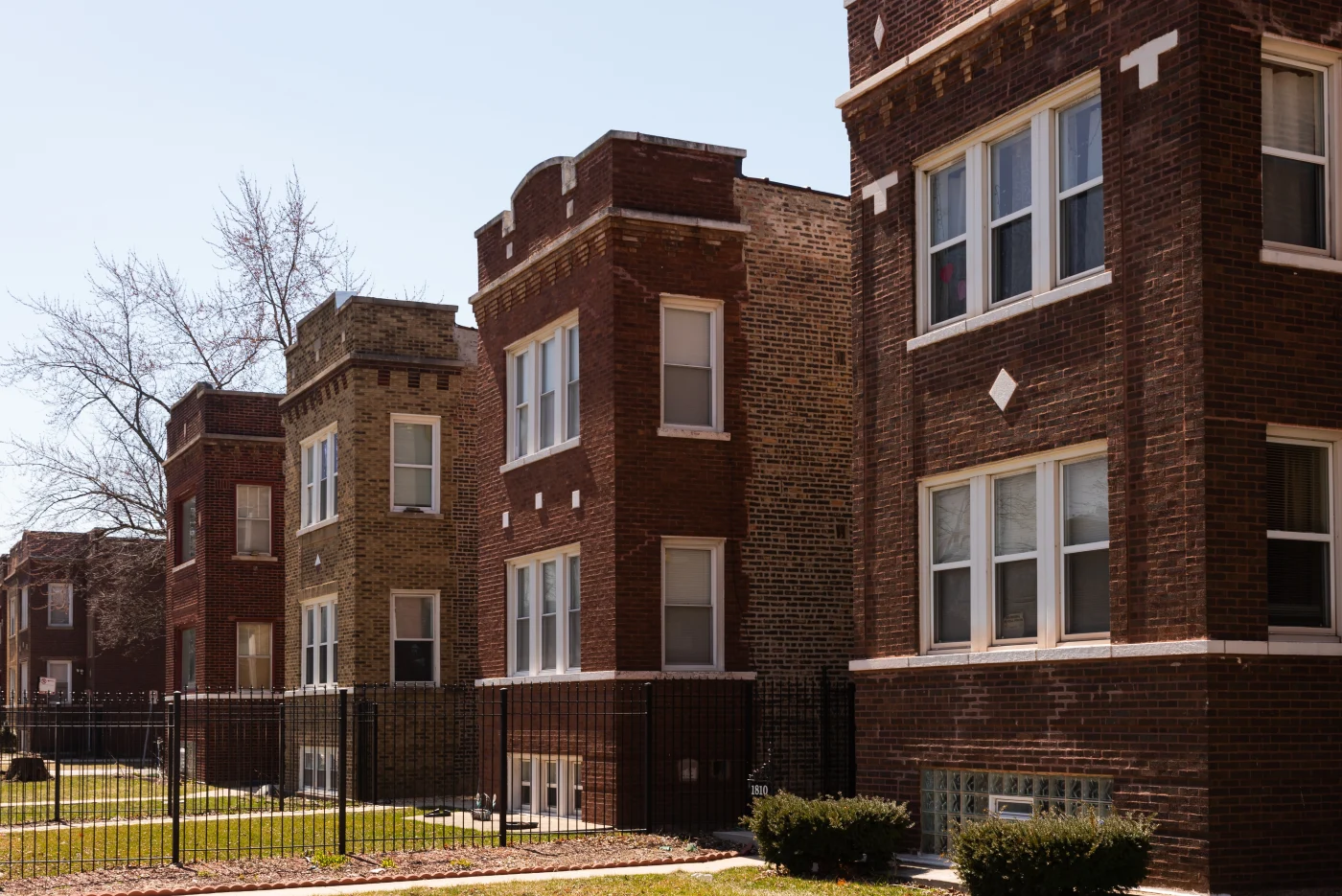 Five two-story, flat brick residential buildings with white windows in the Chicagoland area.