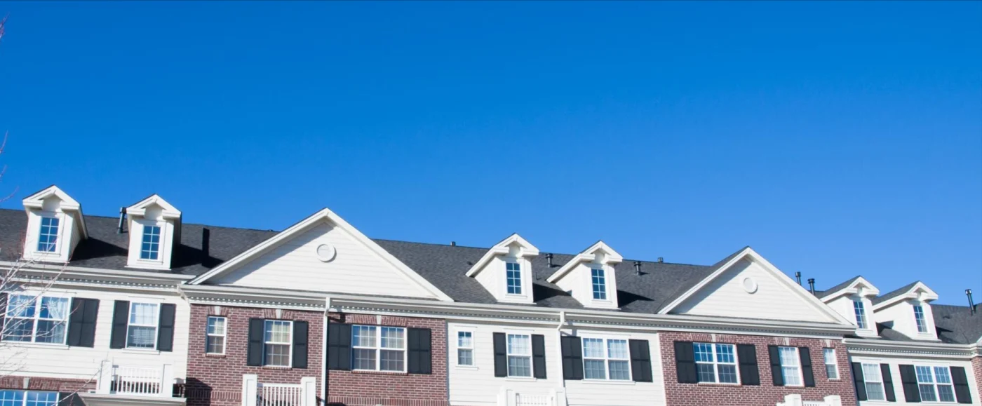 Close-up of an apartment complex roof against a blue sky