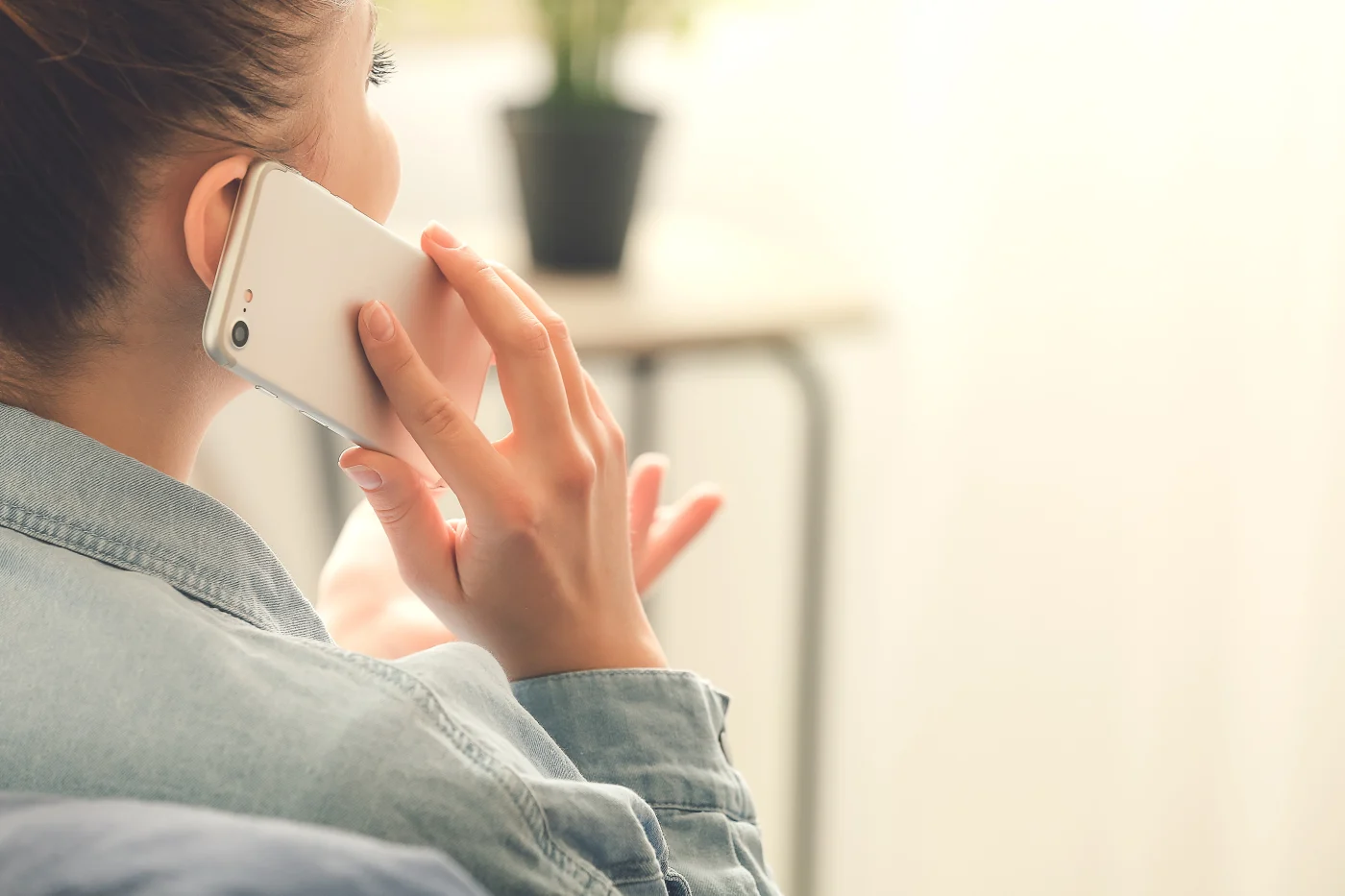 Contact Apex Exteriors In Chicagoland For Residential Roof Repair Services A woman holding a smartphone up to her ear.