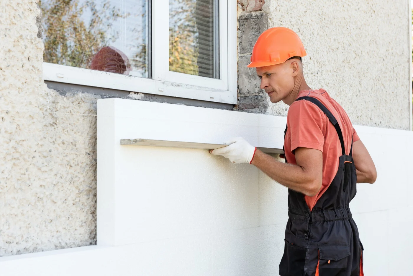 A professional installer carefully places new siding on a home.
