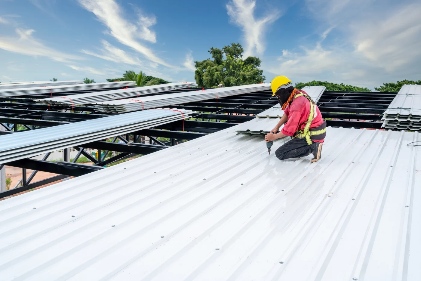 Roofer installing a metal roof on a commercial building