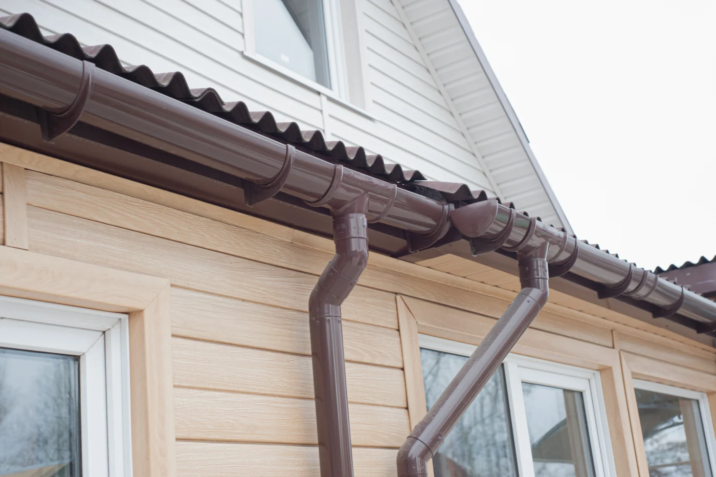 Close-up of brown gutters and downspouts on a home
