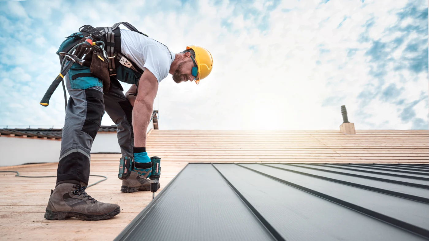 Roofer installing metal roof panels on Downers Grove home