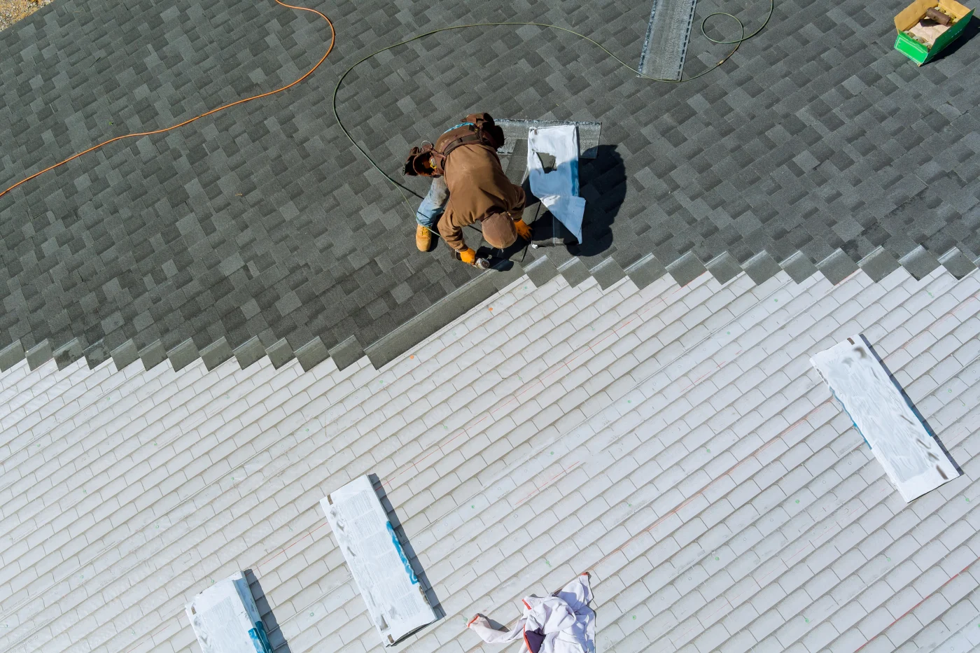 Professional roofer replacing shingle on a residential roof