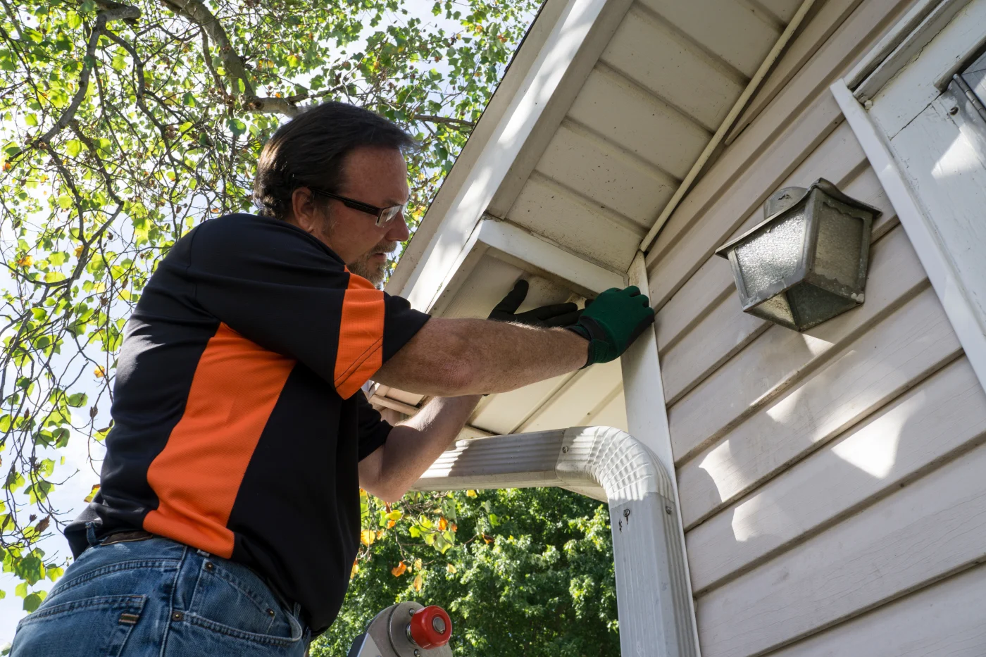 Man repairing siding on a house
