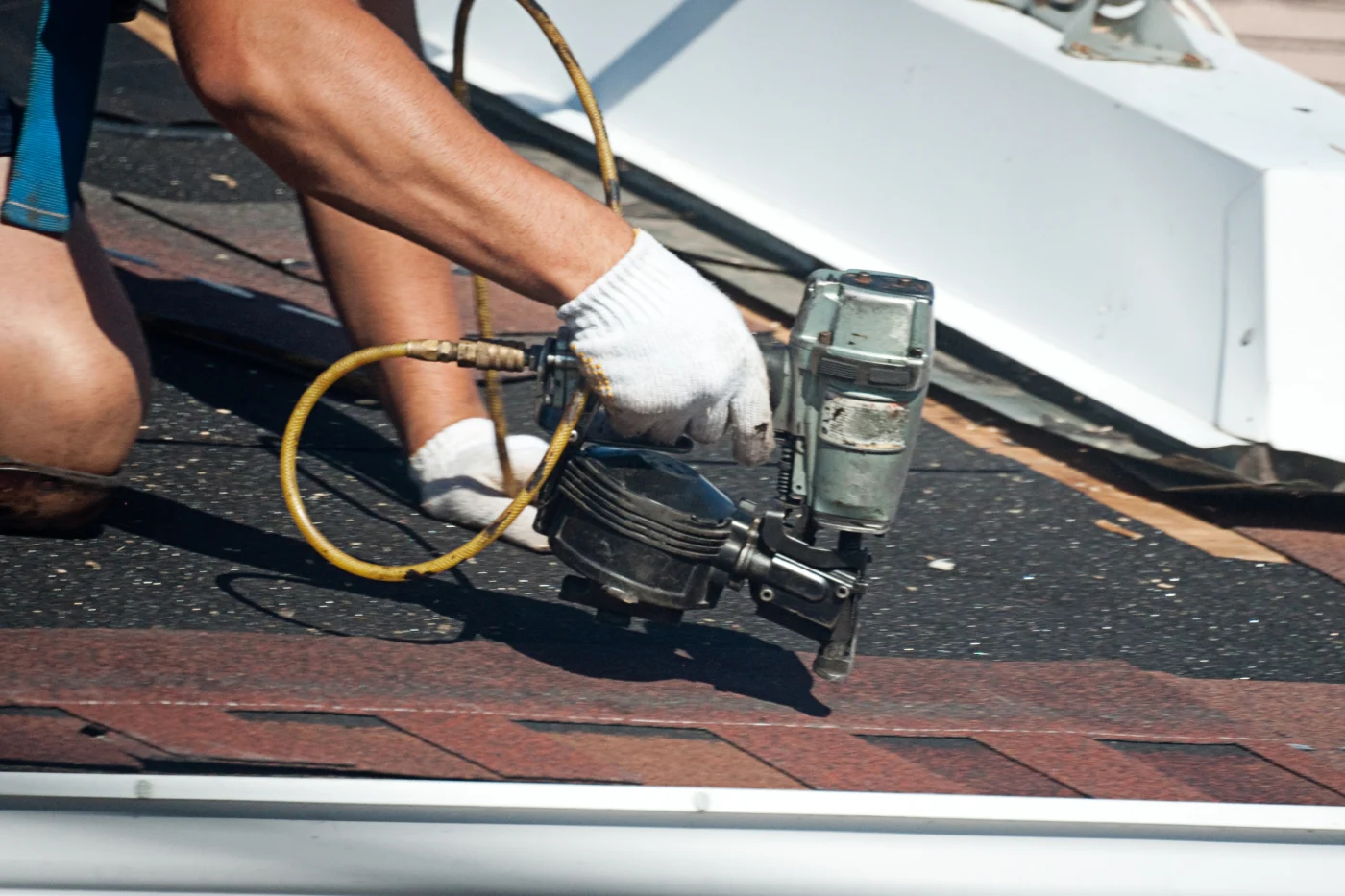 Expert roofer patching up shingles on a roof