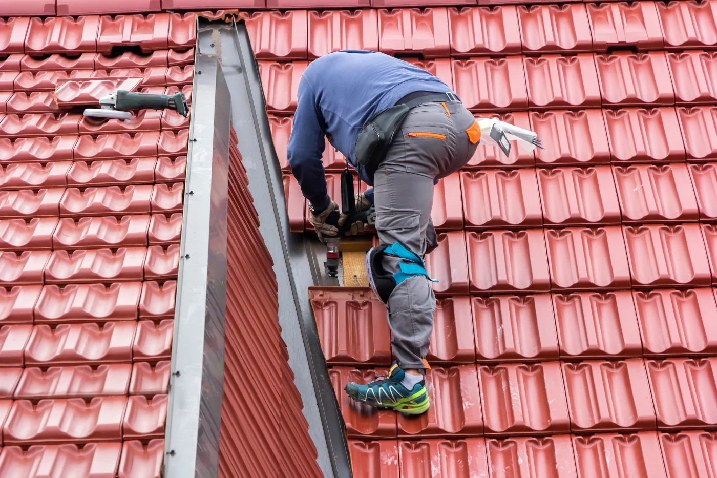 Roofer repairing a tile roof