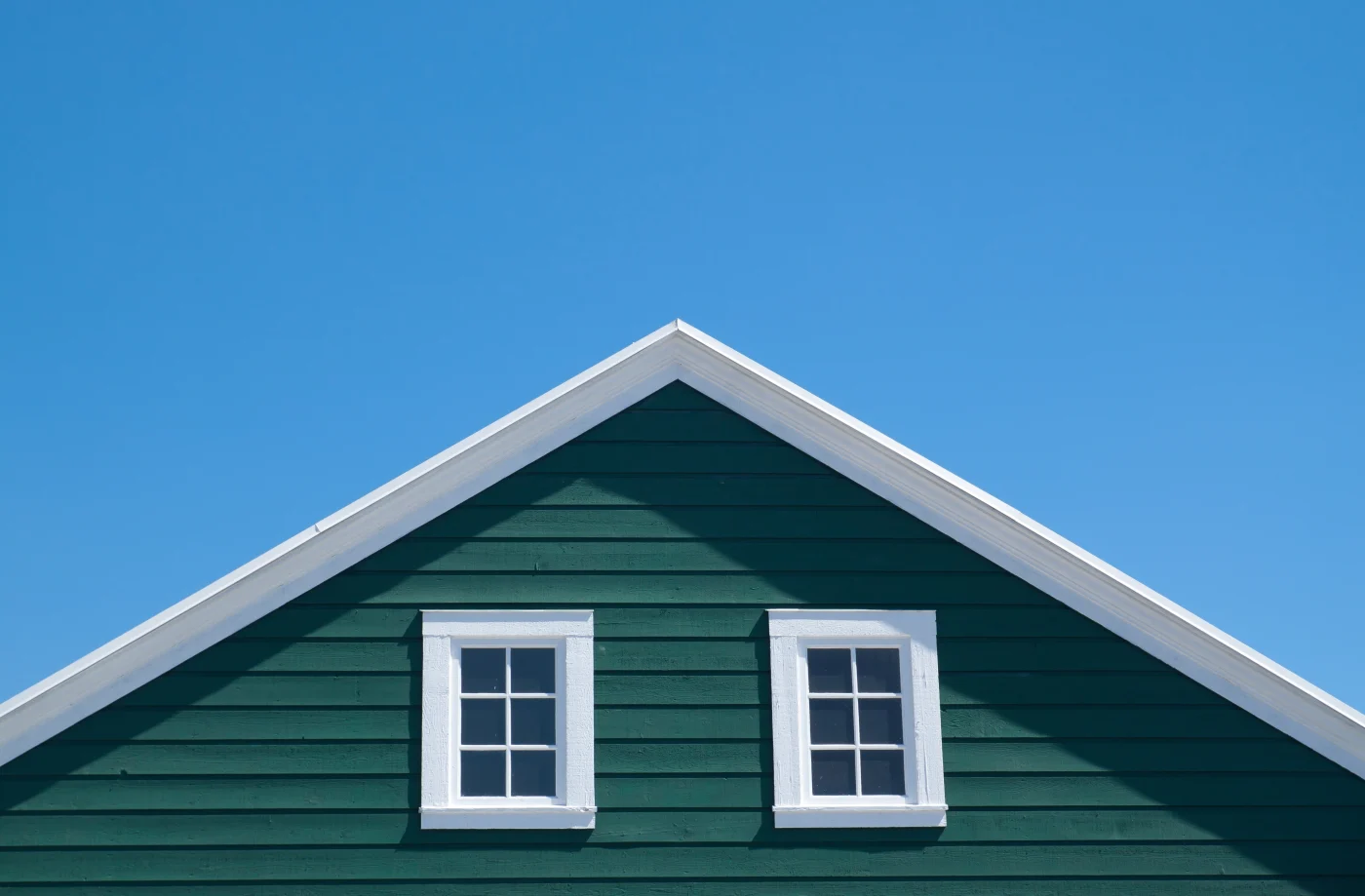 Green House And White Roof With Blue Sky In Sunny Day