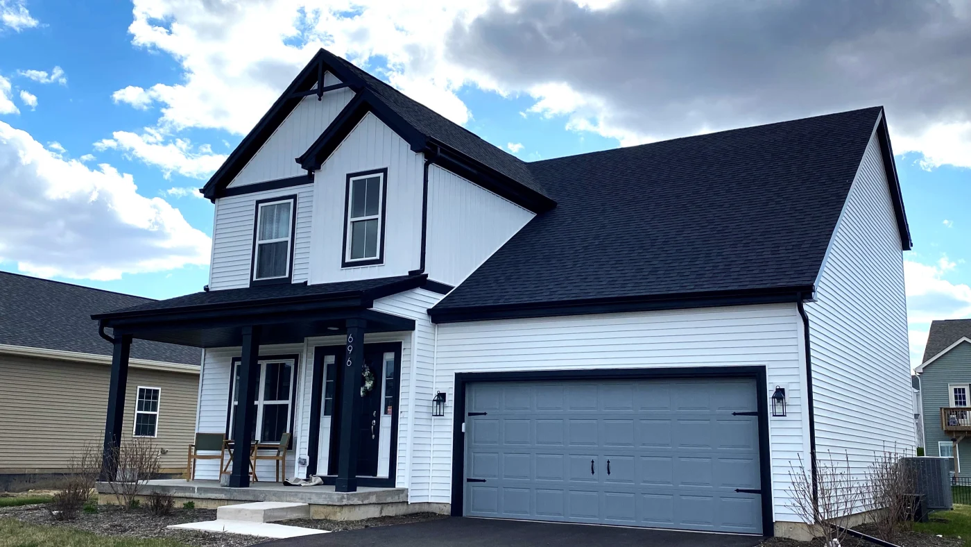 Gorgeous two-story Illinois home with white siding, white framed and black trimmed replacement windows, and black asphalt shingle roof