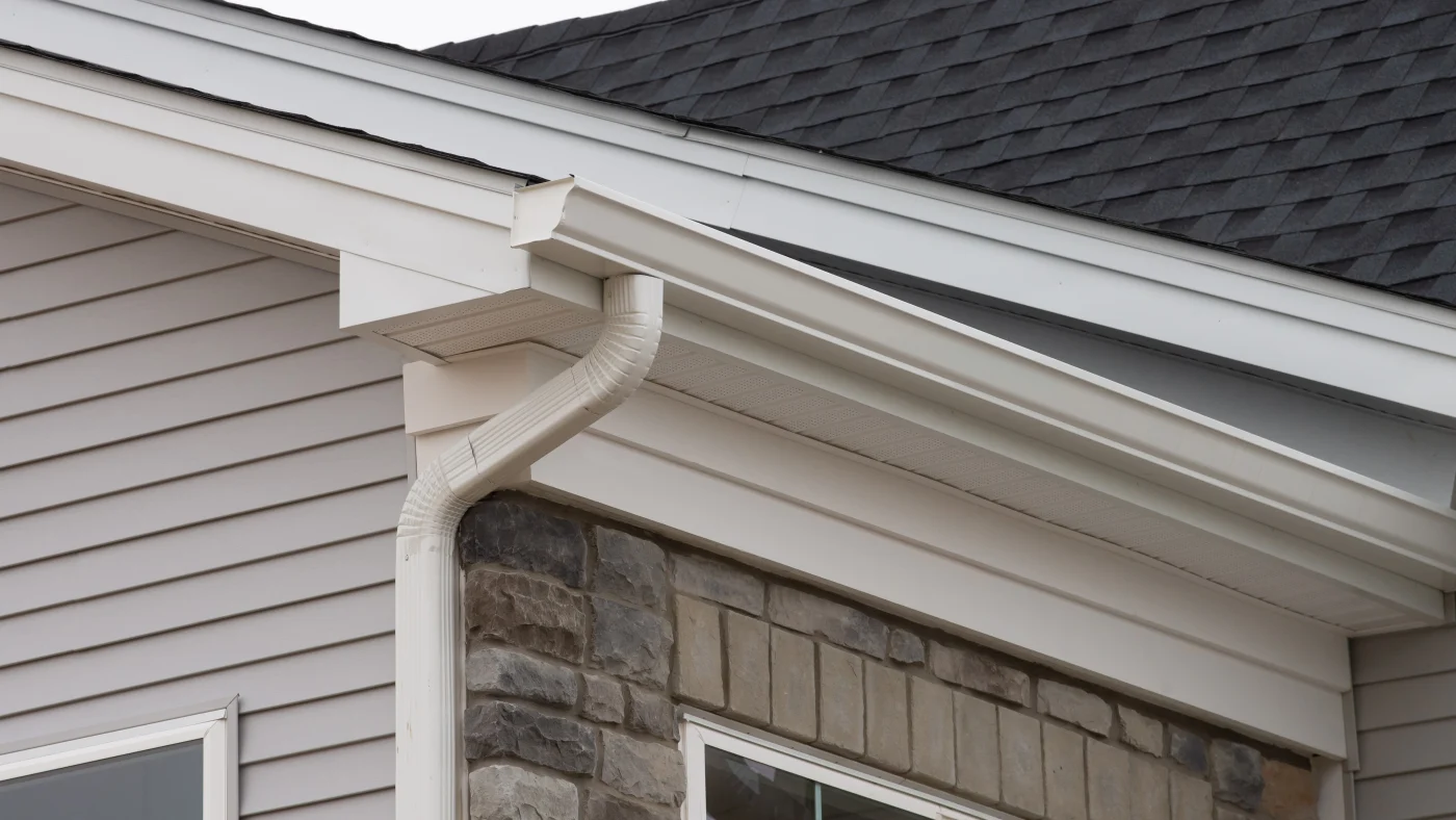 Home corner with new white seamless gutters on it