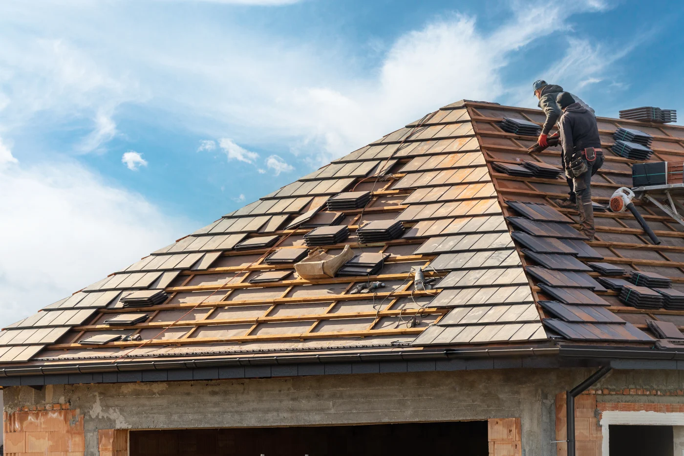 Roofers replacing a tile roof on a home
