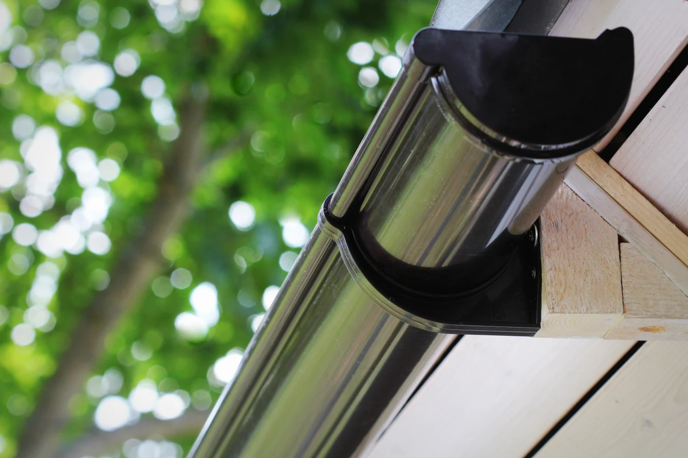 Close-up image of a dark-colored half-round gutter on a house