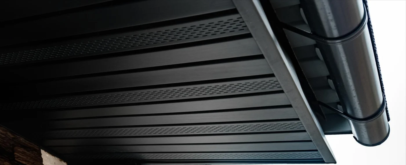 Close-up of black gutters and roof soffits