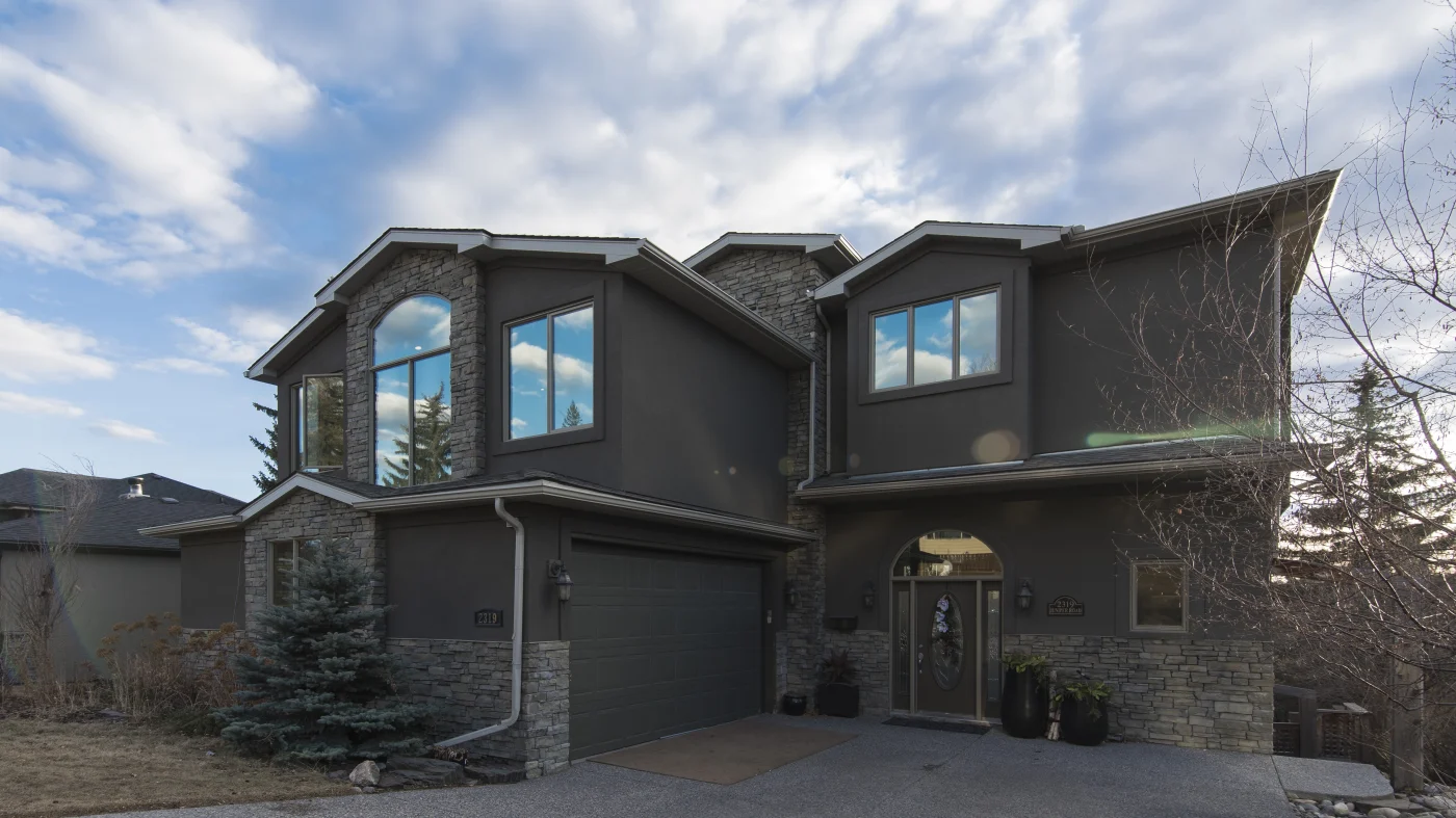 Gorgeous modern home with a gray siding and reflective replacement windows
