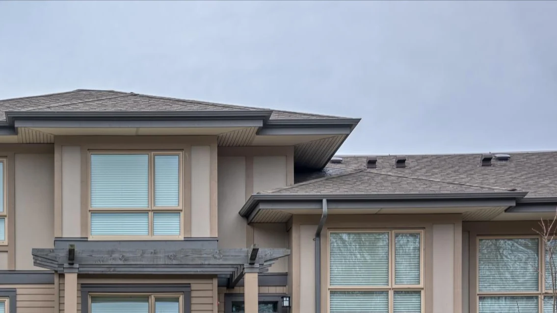 Image of large windowed townhouses with grey gutters