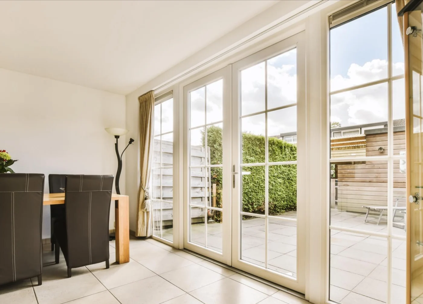 Image of dining room with large glass patio doors leading to an outdoor space