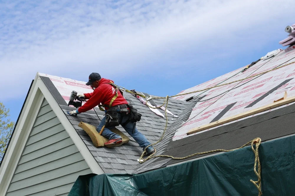 A thoughtful roofer carefully installs a new roof on a new apartment.