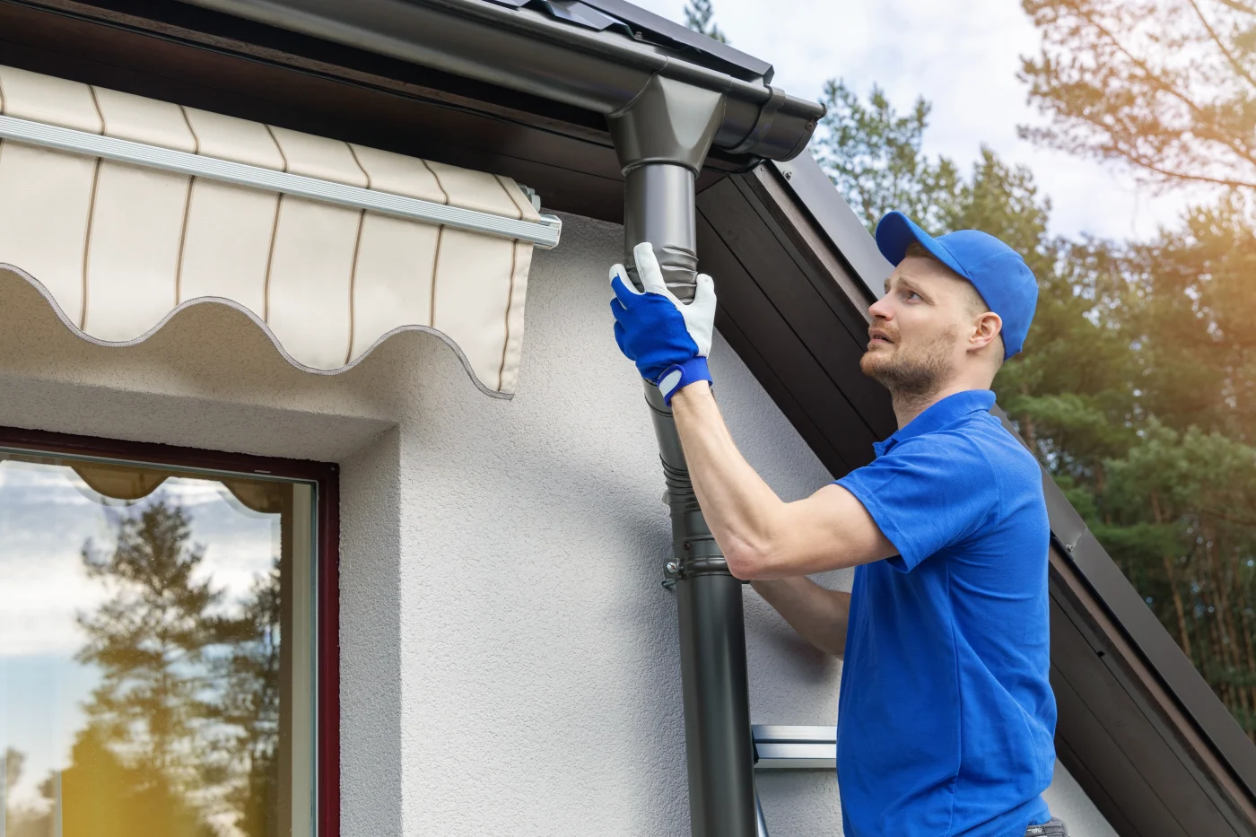 Expert roofing contractor installing premium gutters on a house