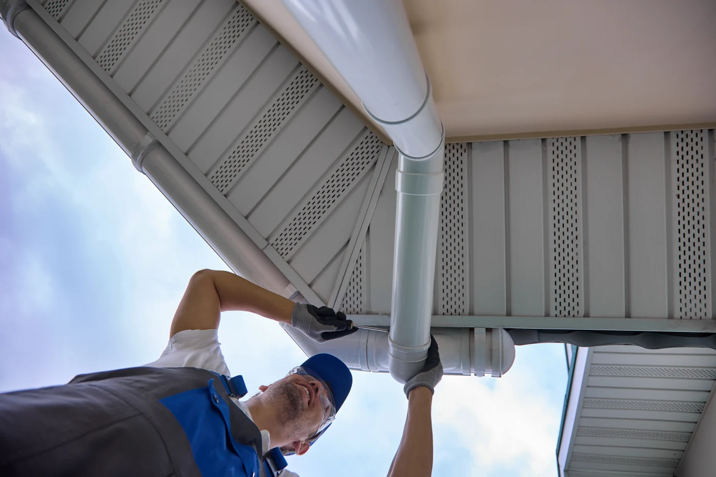 A man working on the gutter area of a home