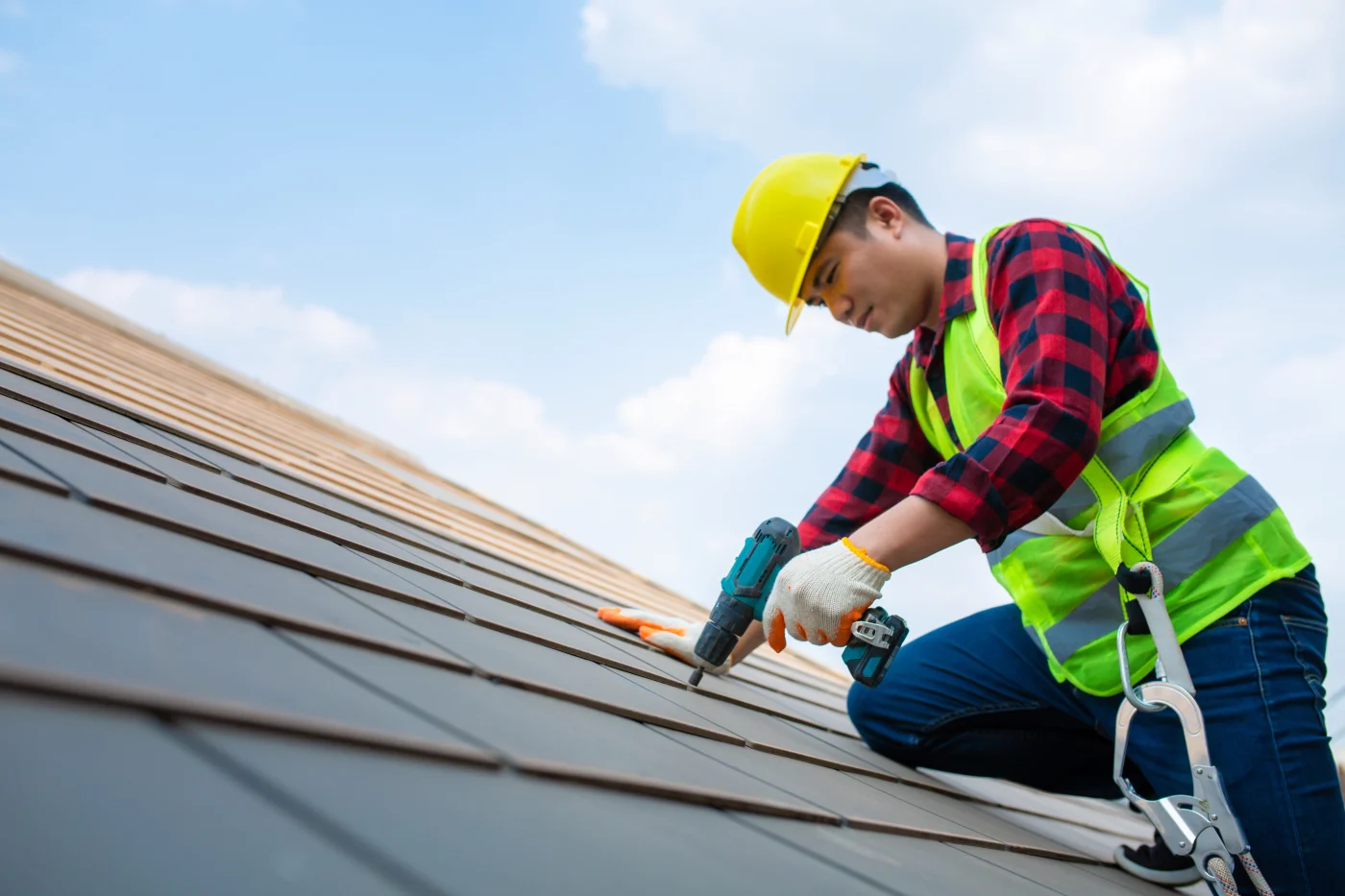 Construction Workers Fixing Roof Tiles, With Roofing Tools, Electric Drills Used On Roofs In Safety Kits For Safety. Construction Workers Fixing Roof Tiles, With Roofing Tools, Electric Drills Used On Roofs In Safety Kits For Safety.