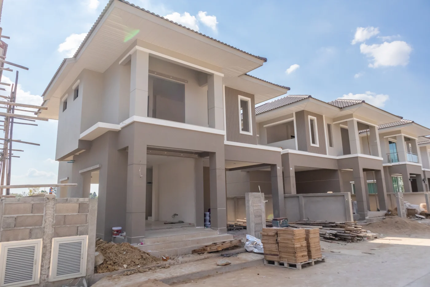 Row of gray stucco townhomes under construction