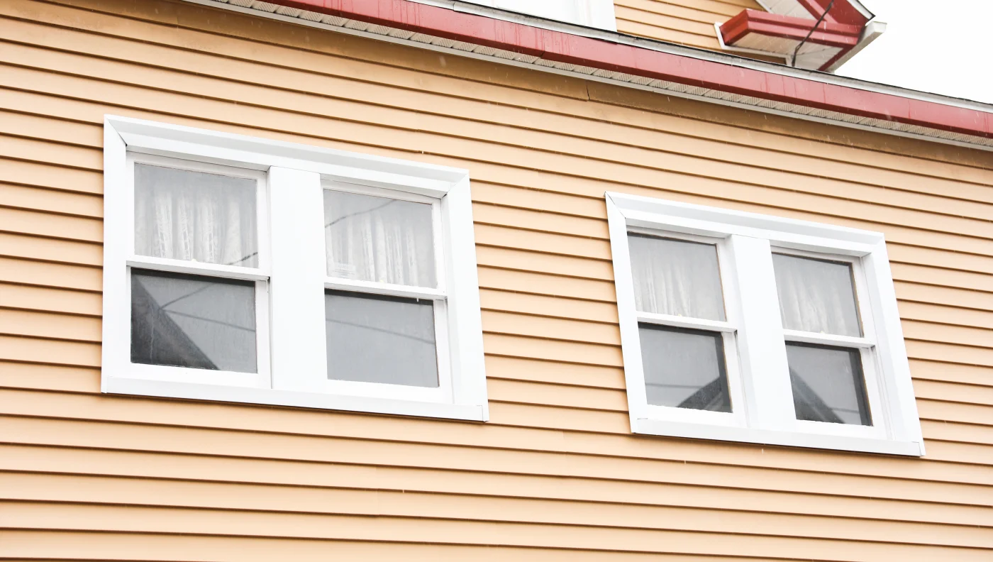Image of small white windows on a yellow house