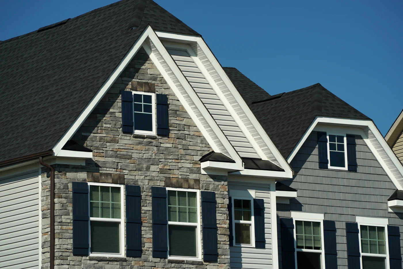 Image of a residential building with grey and brown- colored stone veneer