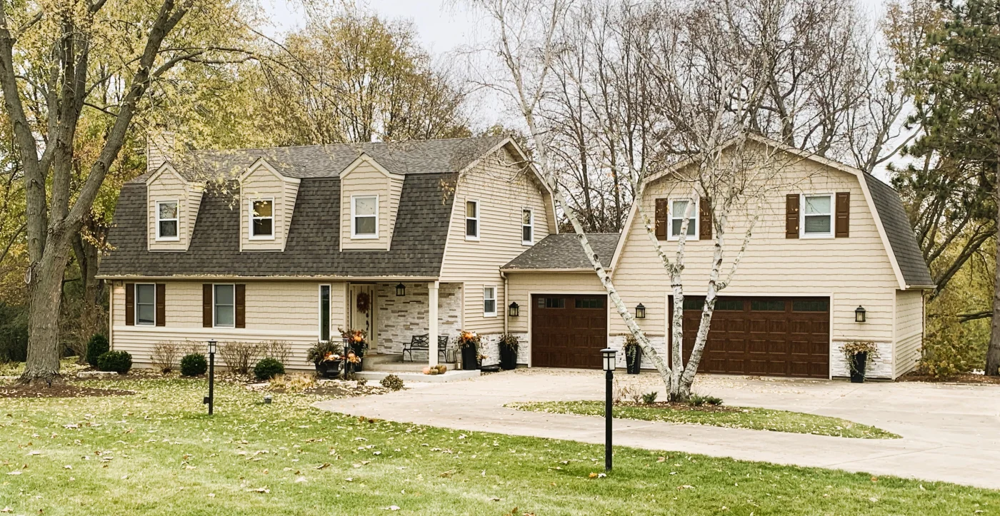 Image of a house with yellow vinyl and versetta stone siding