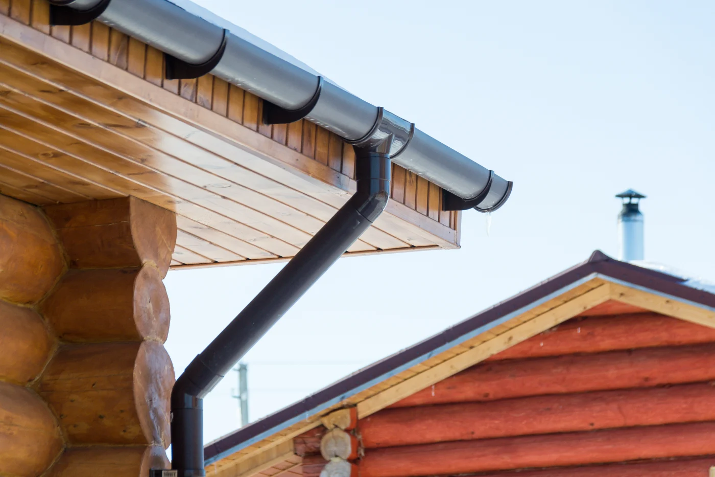 Rich, black metal gutters on the corner of a cabin
