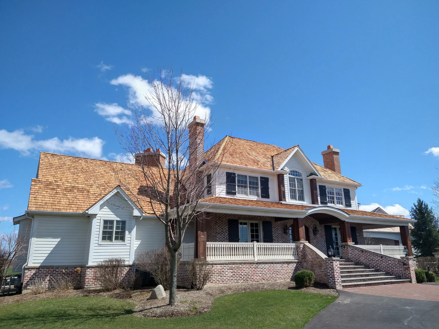 A modern residential home sports a new roof, new windows, and fresh gutters.