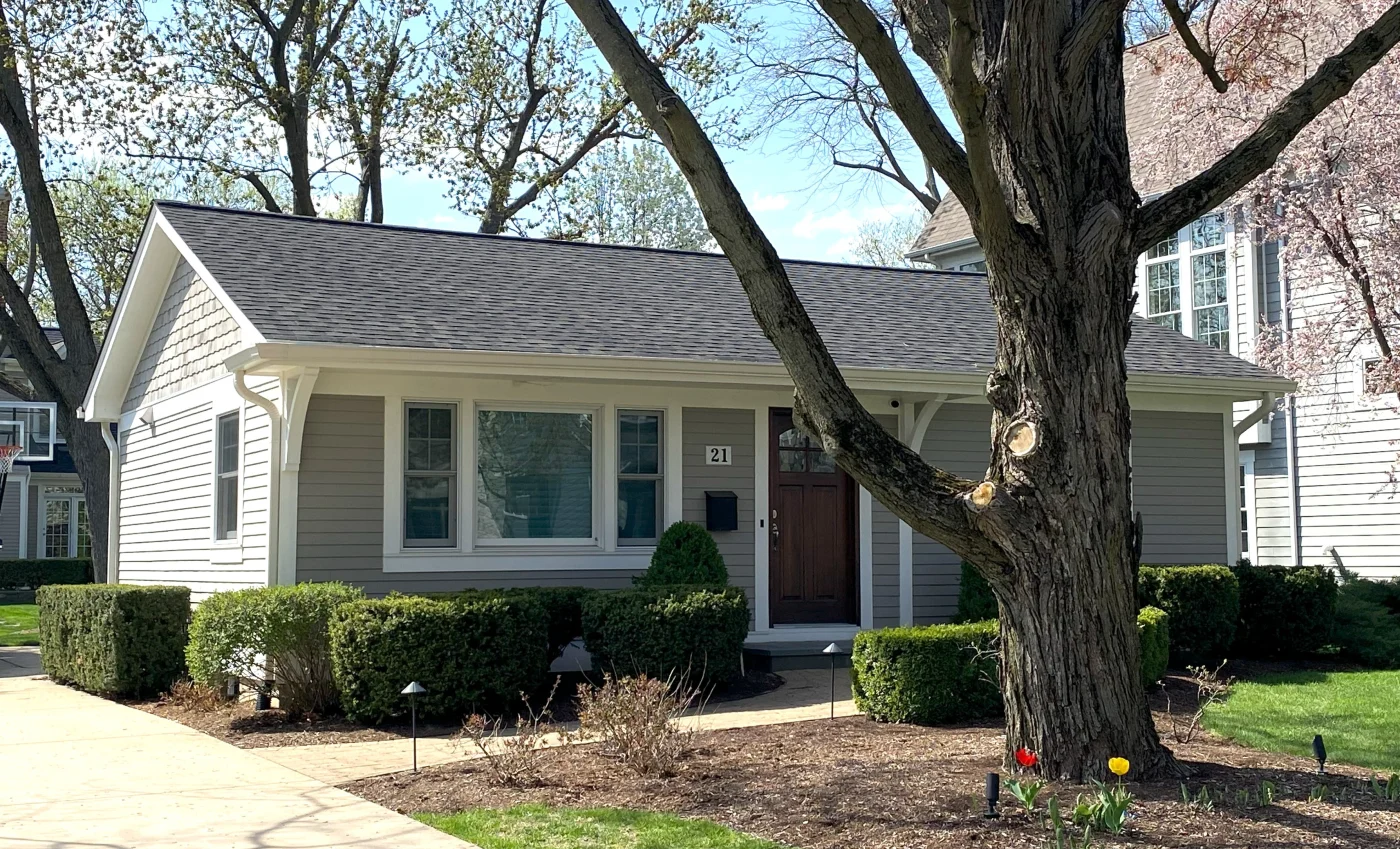 This image features a small in-town home with a white gutter system.