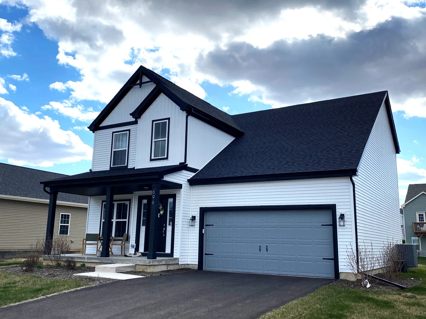 A side view of a 2-story home with a brand new roof and new windows.