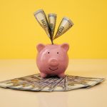 A piggy bank overflows with $100 bills