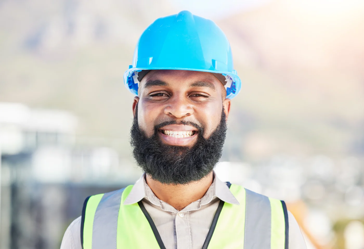 Happy Black Man, Portrait And Architect In City For Professional Construction Or Career Ambition On Site. Face Of African Male Person, Engineer Or Contractor Smile For Industrial Architecture On Roof A smiling roofing contractor with a full beard and blue hard hat