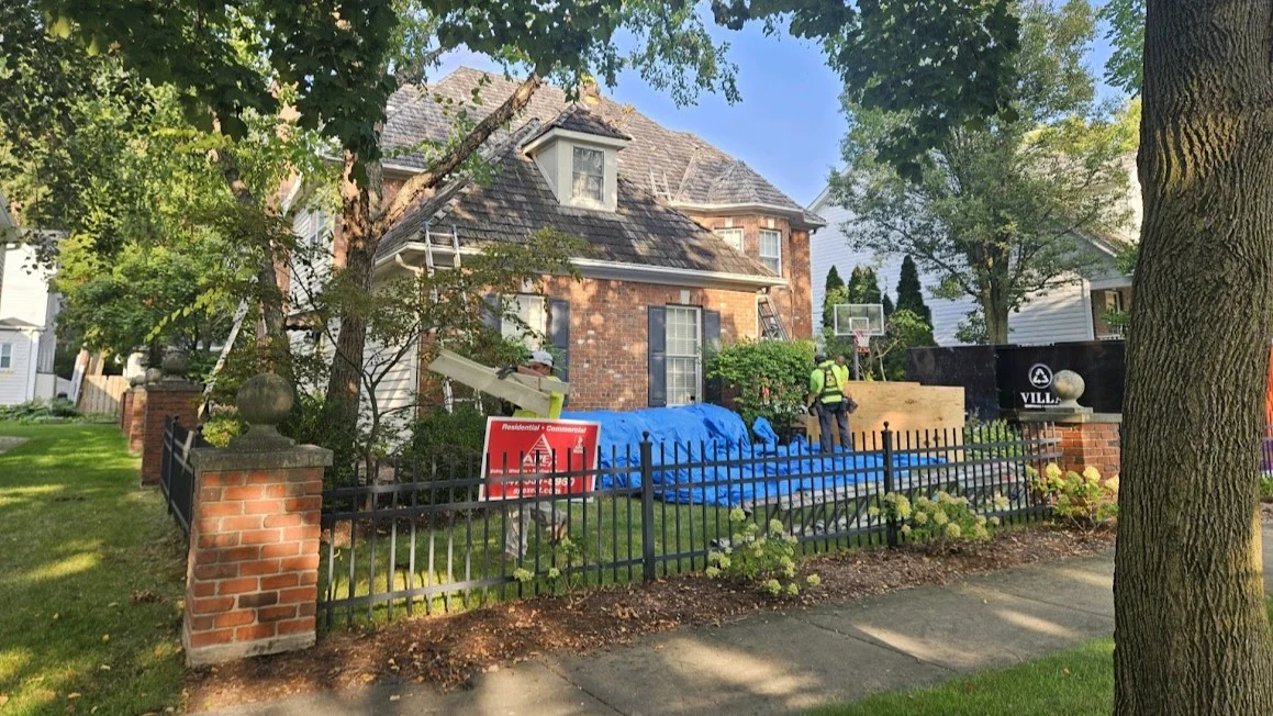 A side of a house with red brick siding in Elmhurst, IL by Apex Exteriors.