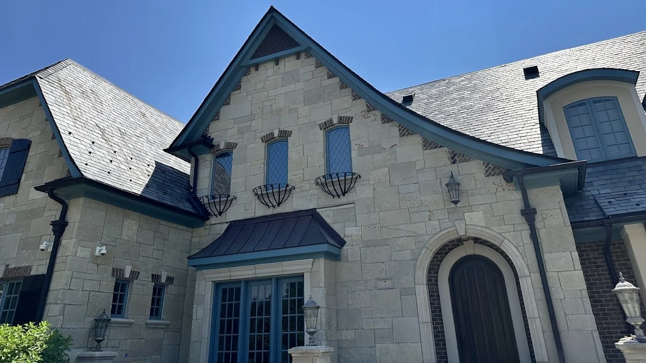 Dependable Slate Roofing Plainfield Il Apex Exteriors Inc The front of a house with beige stone siding in Plainfield, IL, by Apex Exteriors, Inc.