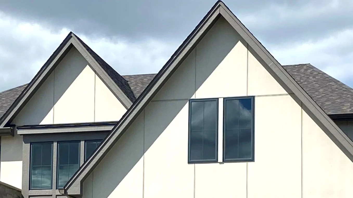 Looking at the second-floor windows of a house with beige siding in Bloomingdale, IL by Apex Exteriors.
