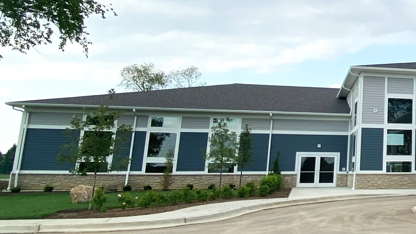 The side of a commercial building with blue and gray siding with white trim in Elmhurst, IL by Apex Exteriors.