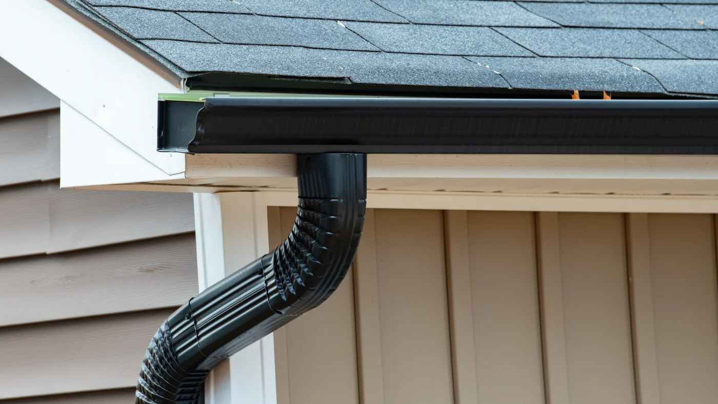 A close-up of black gutters on a home with a black roof in LaGrange, IL by Apex Exteriors.
